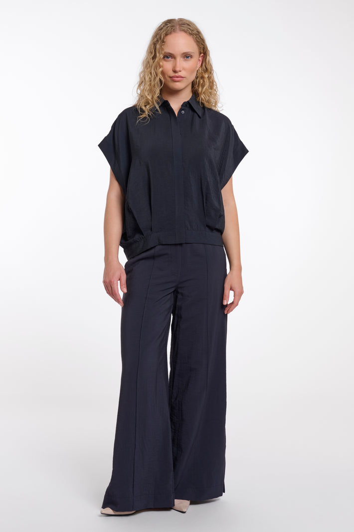 Donkerblauwe blouse Imela van Rino & Pelle met stijlvolle kraag en knoopsluiting, gedragen door een model.
