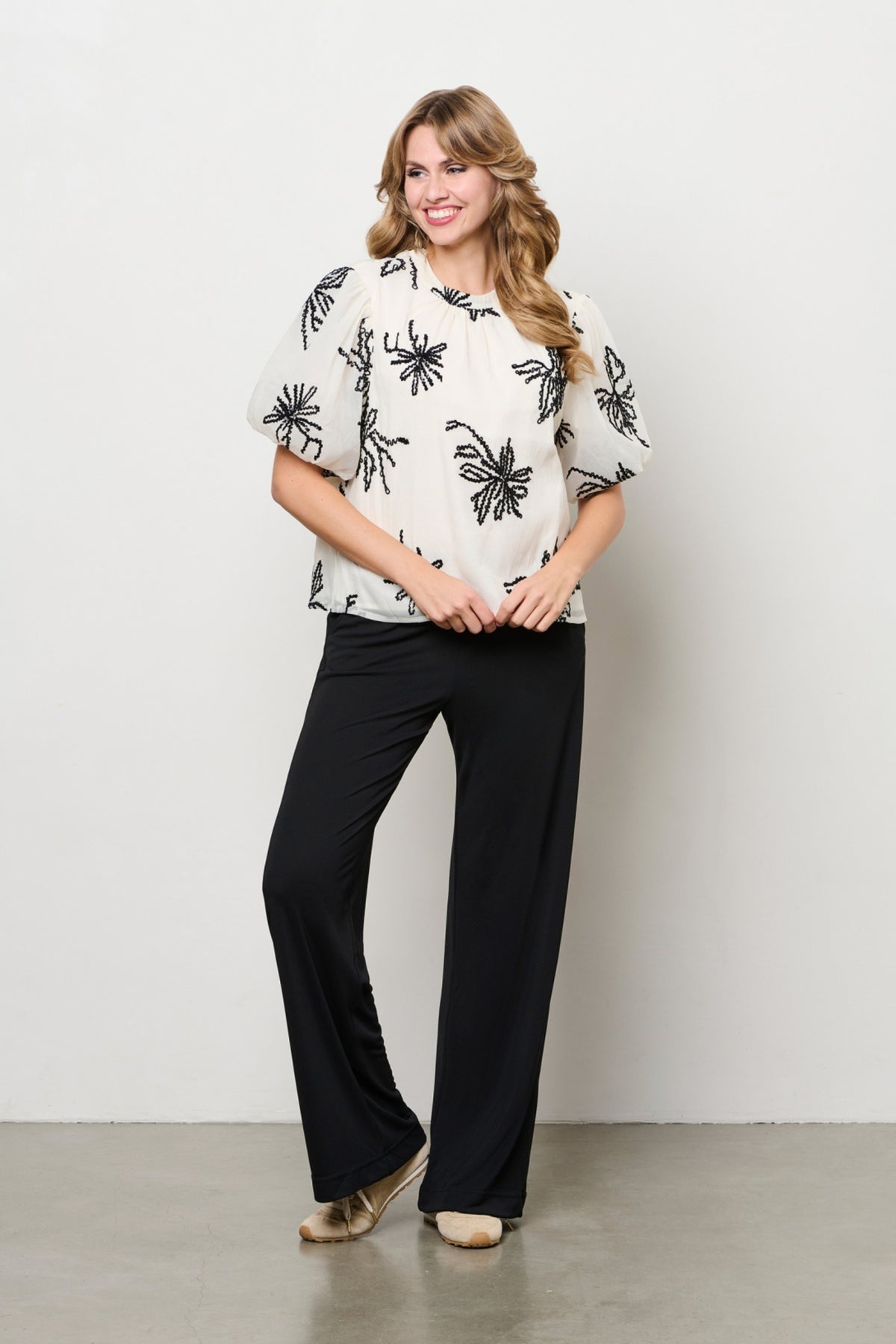 Beige blouse Wyanne van &Co woman met 3/4 mouwen en losvallende pasvorm, gedragen door een model.