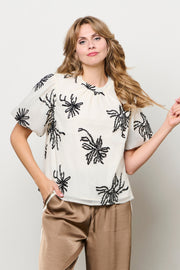 Lichte beige blouse Wyanne van &Co woman, getailleerd model met knoopsluiting en lange mouwen, gedragen door een model.