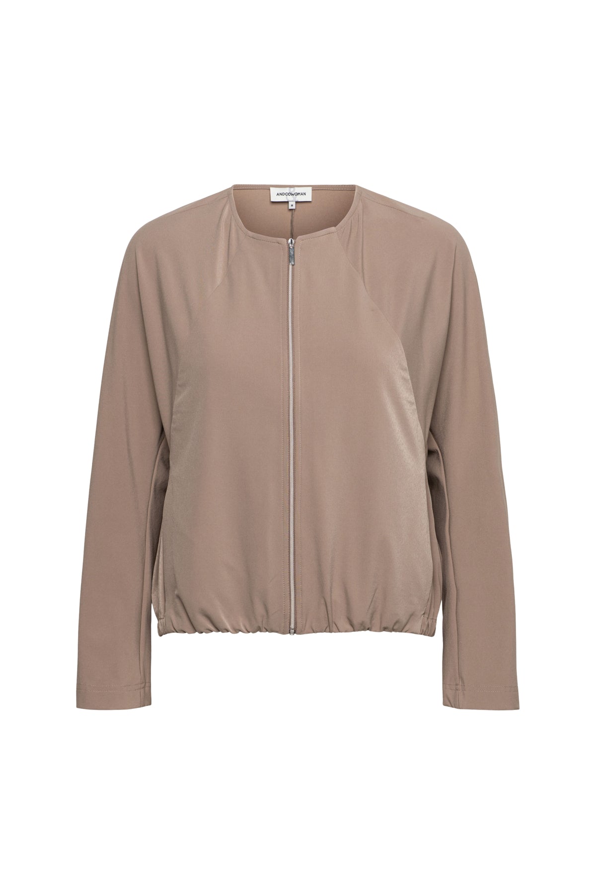 Reisjasje Pihla in taupe van &Co woman, getailleerd met rits en zakken, gedragen door model, close-up van de jas.