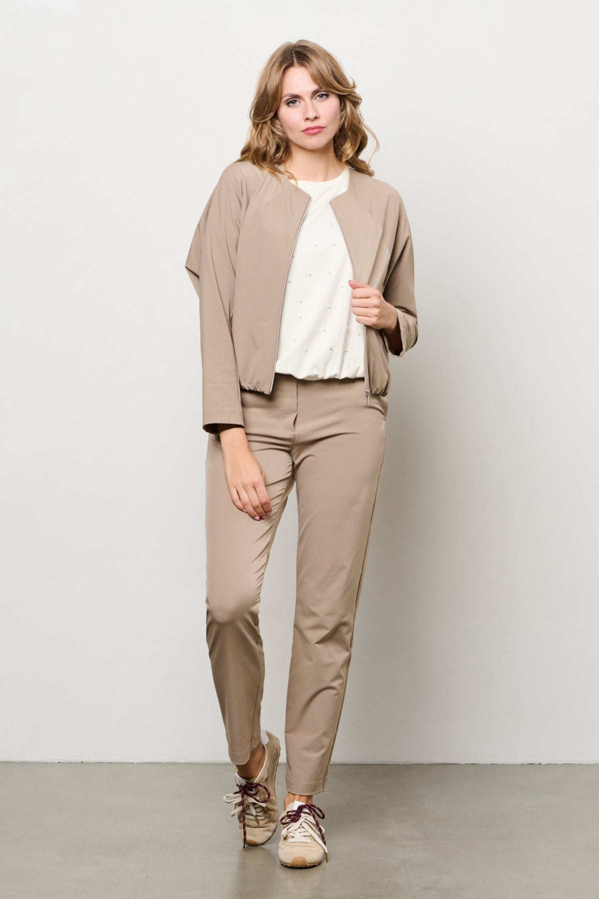 Taupe reishouddoek van &Co woman met gewatteerde vulling en capuchon, geschikt voor reizen en koude dagen.