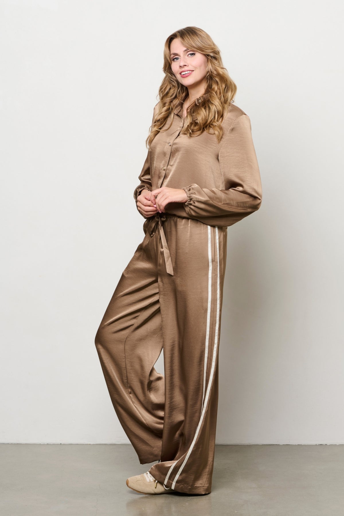 Taupe broek Neomi van &Co woman, getailleerd model met steekzakken, gedragen door een vrouw met een witte blouse.