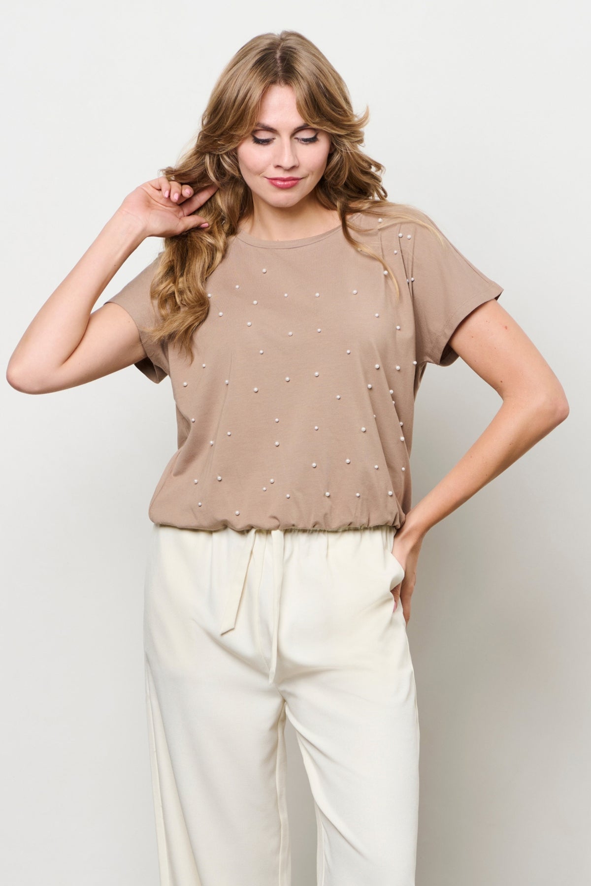 Taupe top van &Co woman, model Terese, met korte mouwen en ronde hals, gedragen door een model.