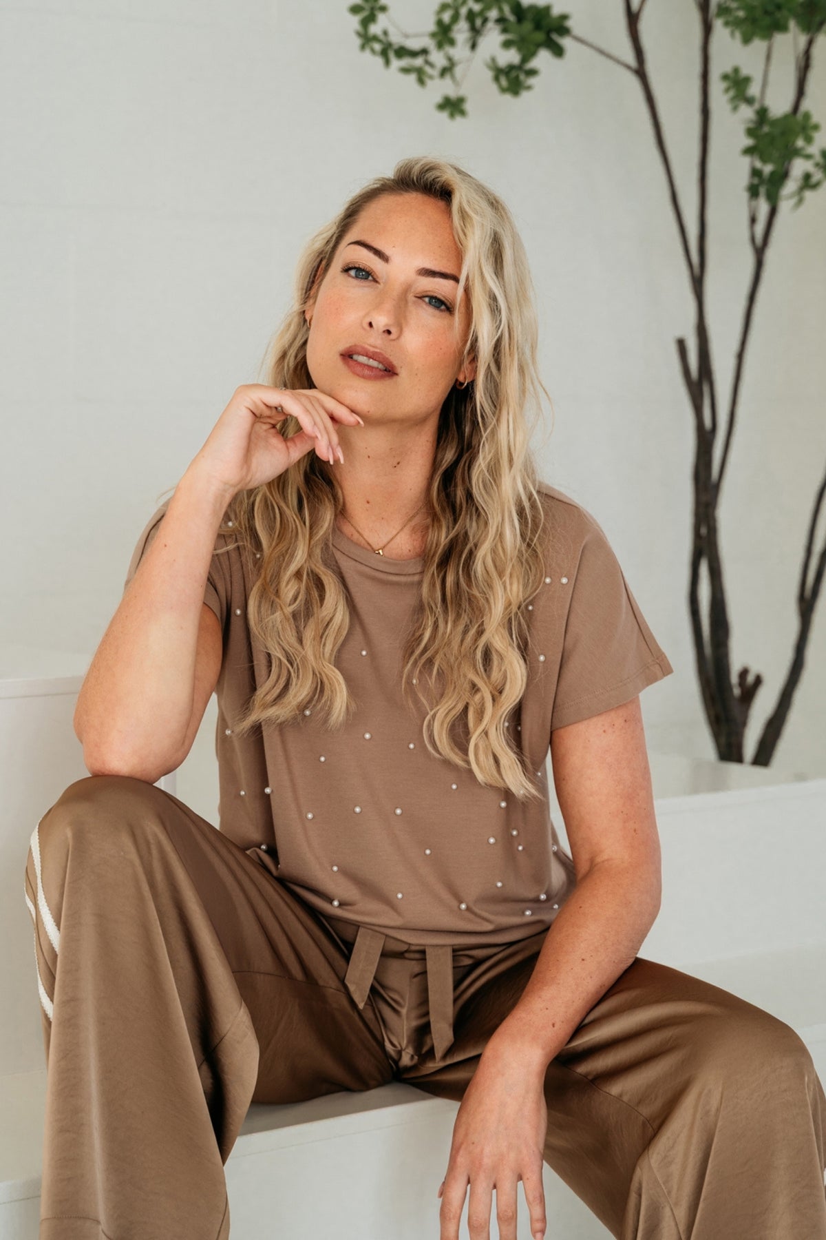 Taupe top Terese van &Co woman, zichtbaar met ronde hals en korte mouwen, gedragen door een model.