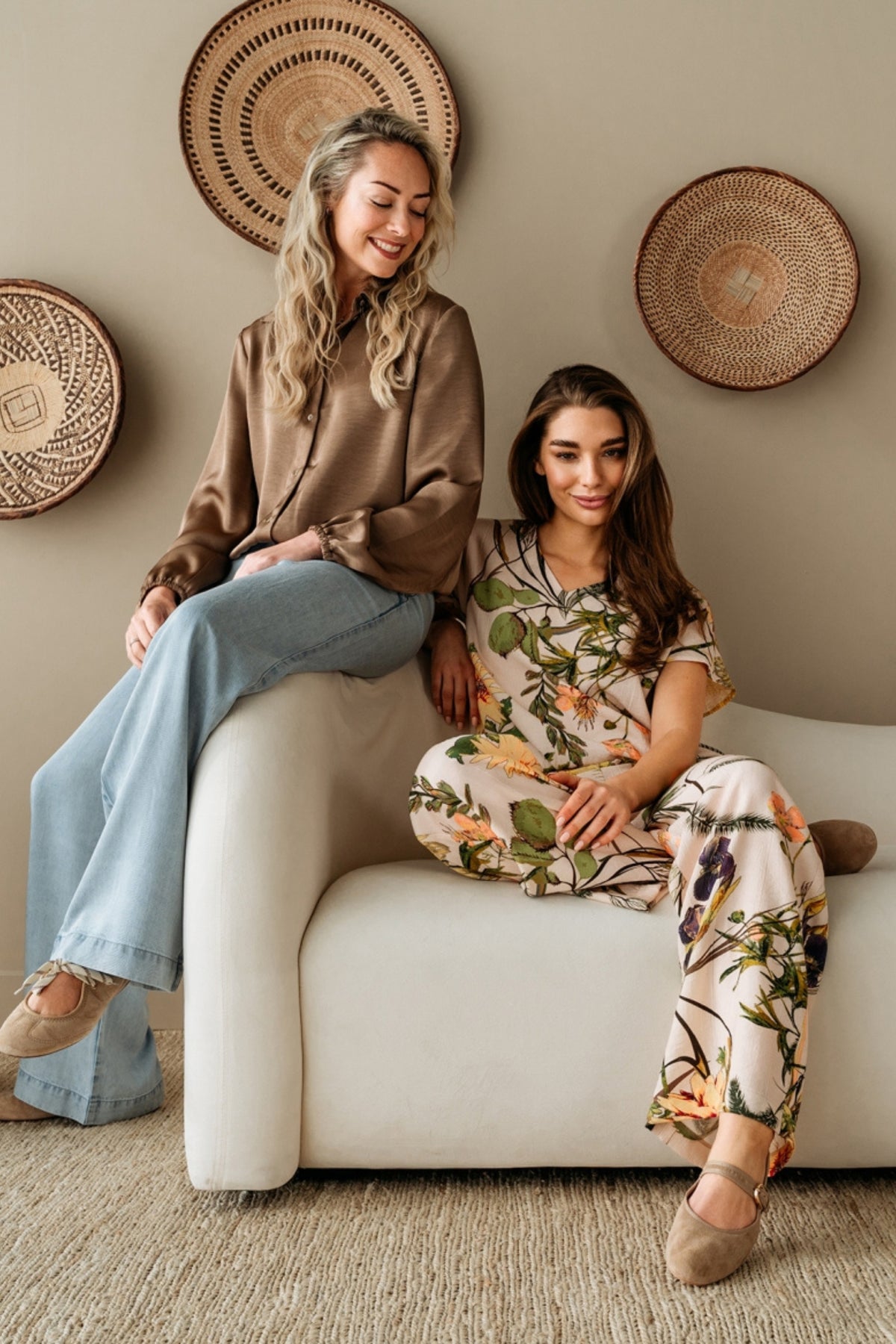 Roze bloemtop van &Co woman met kleurrijk bloemendessin, gedragen door een model, op een witte achtergrond.