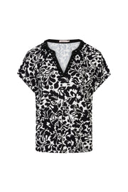 Gouden print top van EsQualo, model Larissa, met elegante details en zachte stof, gedragen door een model.