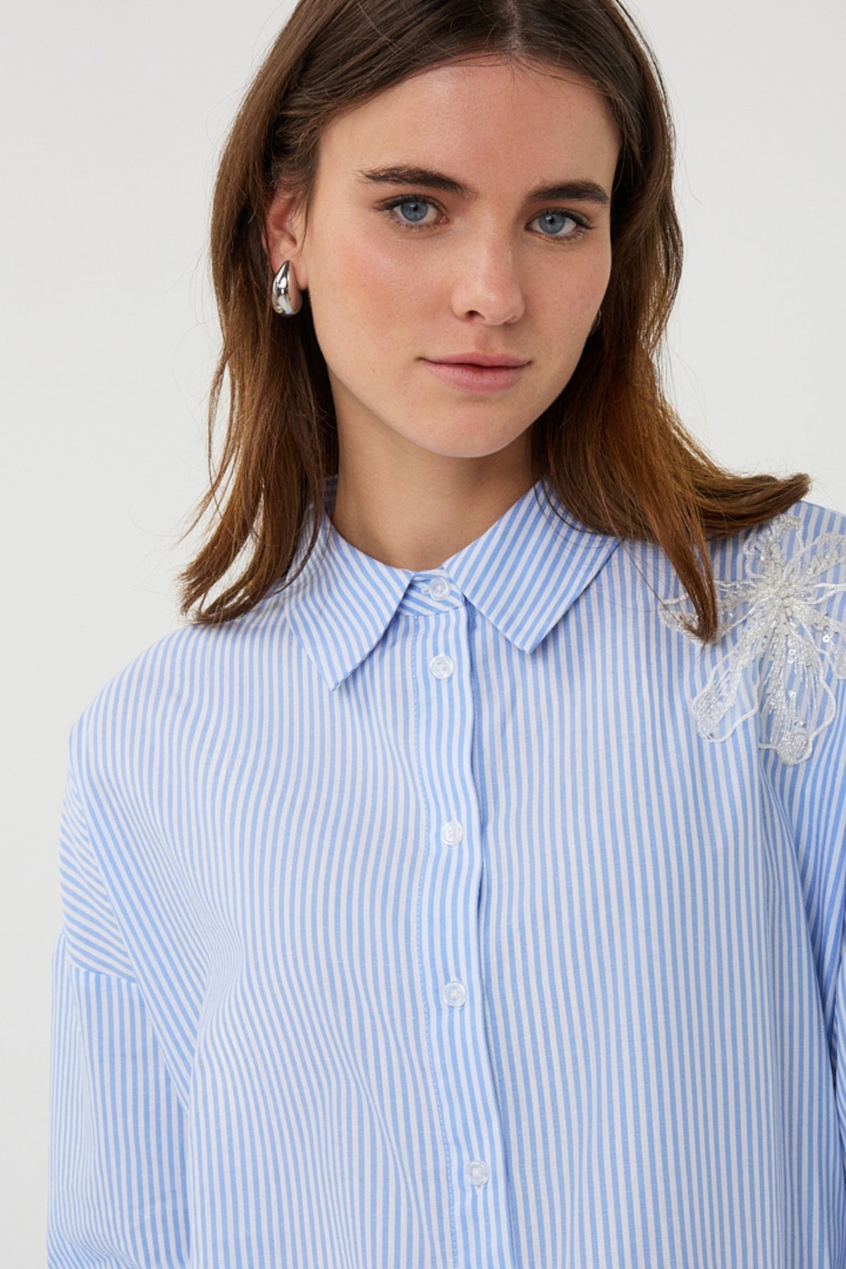 Witte en blauwe gestreepte blouse met bloempatches van EsQualo, getoond op model.