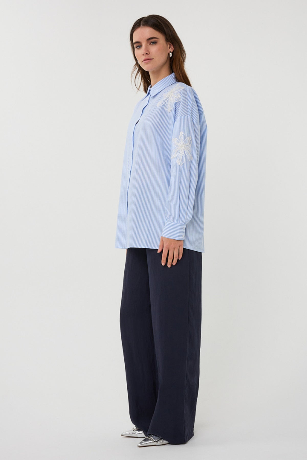 Witte en blauwe gestreepte blouse met bloemenpatch van EsQualo, gedragen door een model op de foto.