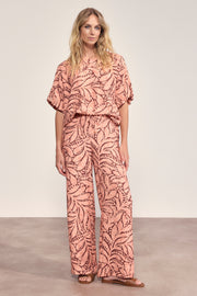 Lieve peachkleurige Tramontana Leaf Luxe Print broek met opvallend bladpatroon, model Larissa, voor een elegante look.