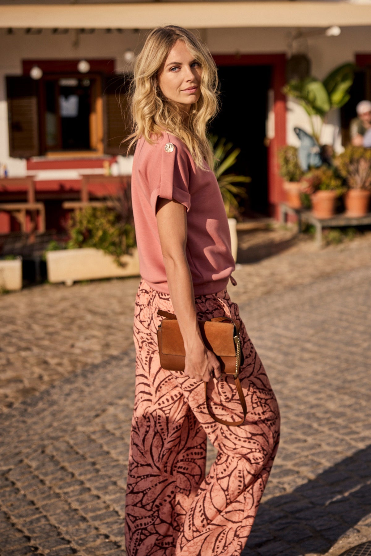 Liefst natuurlijke afbeelding van de Tramontana Leaf Luxe Print Peach broek met elegante print, gedragen door een model.