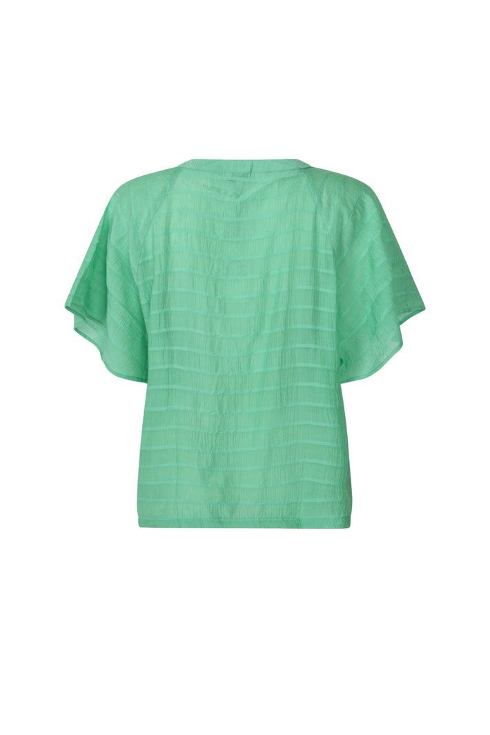 Mintgroene blouse Desi van Zoso met elegante pasvorm en knoopdetail, gedragen door een model op een witte achtergrond.