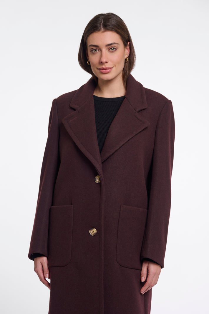 Donkerbruine Rino & Pelle coat Cecile in chocoladekleur met knopen en warme voering, gedragen door een model.