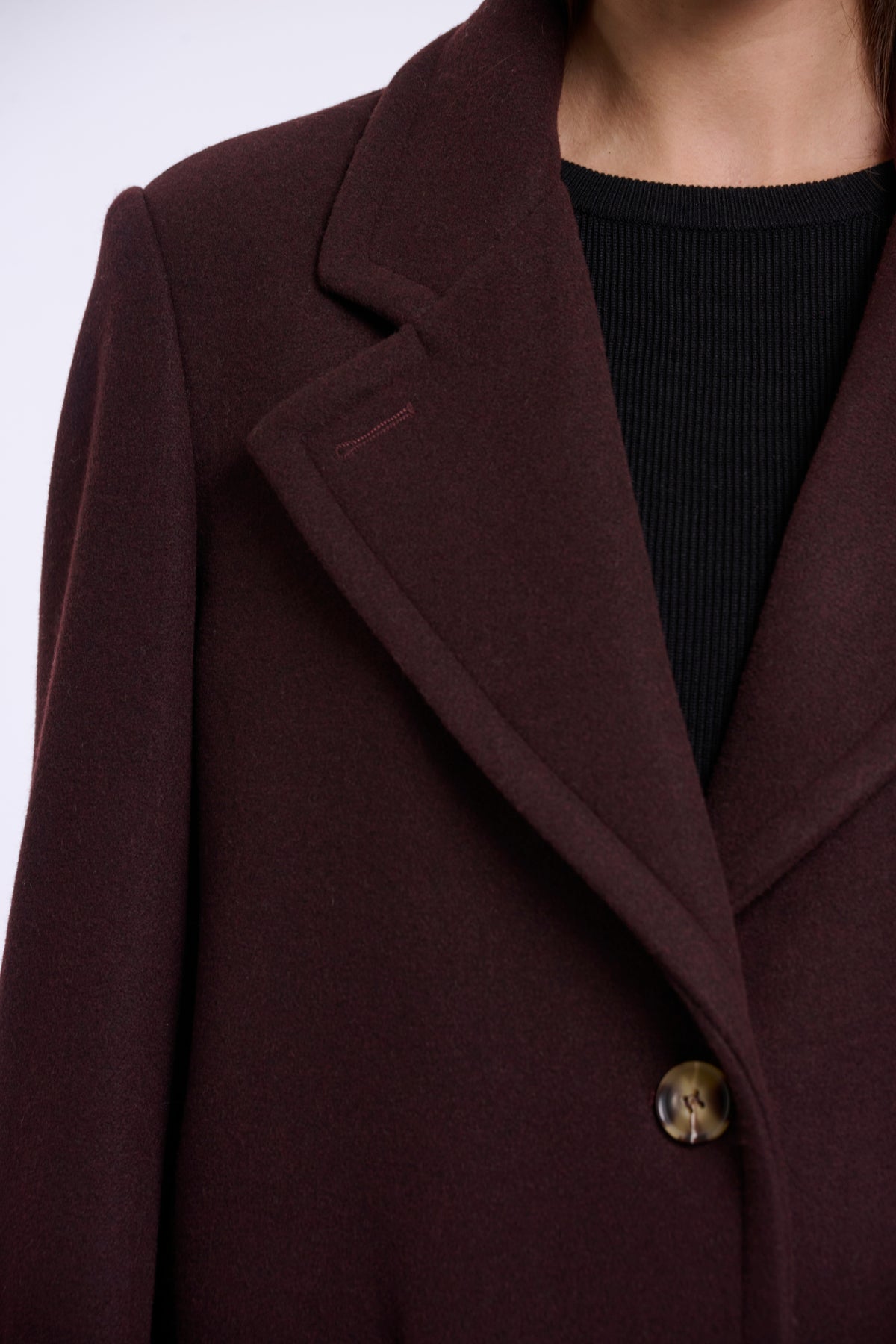 Donkere Rino & Pelle Cecile chocoladebruine coat met knopen en kraag, gedragen door een model op een witte achtergrond