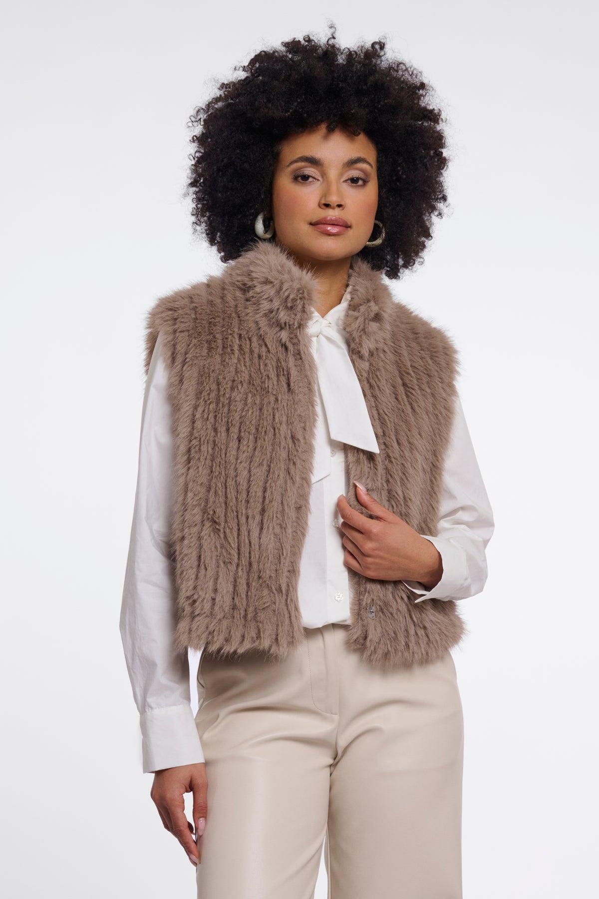 Rino & Pelle Dava Mocha Latte gilet, lichtbruin met knopen, gedragen door een model, close-up van de stof en pasvorm