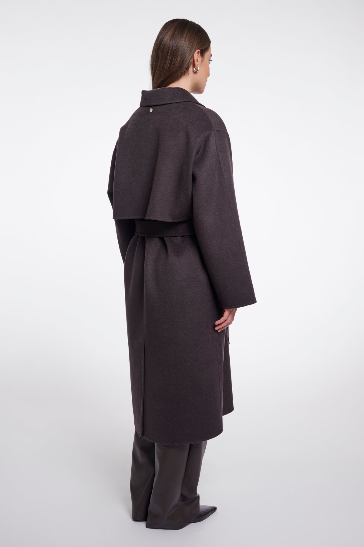 Donkere bruin Hayley jas van Rino & Pelle, zichtbaar met capuchon en stijlvolle details, gedragen door een model.