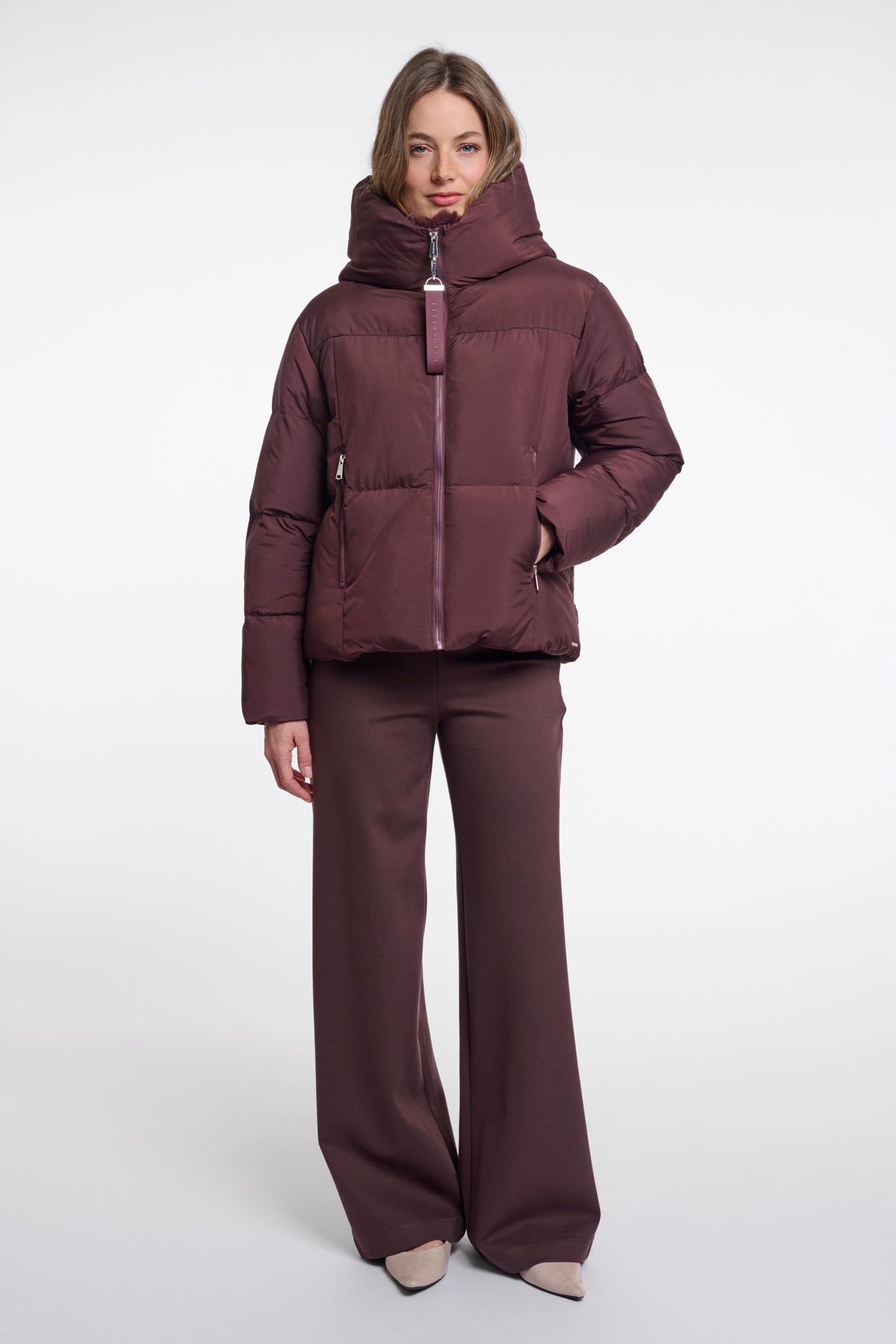 Donkerbruine Rino & Pelle Joni Fudge jas met capuchon en ritssluiting, getoond op een hanger.