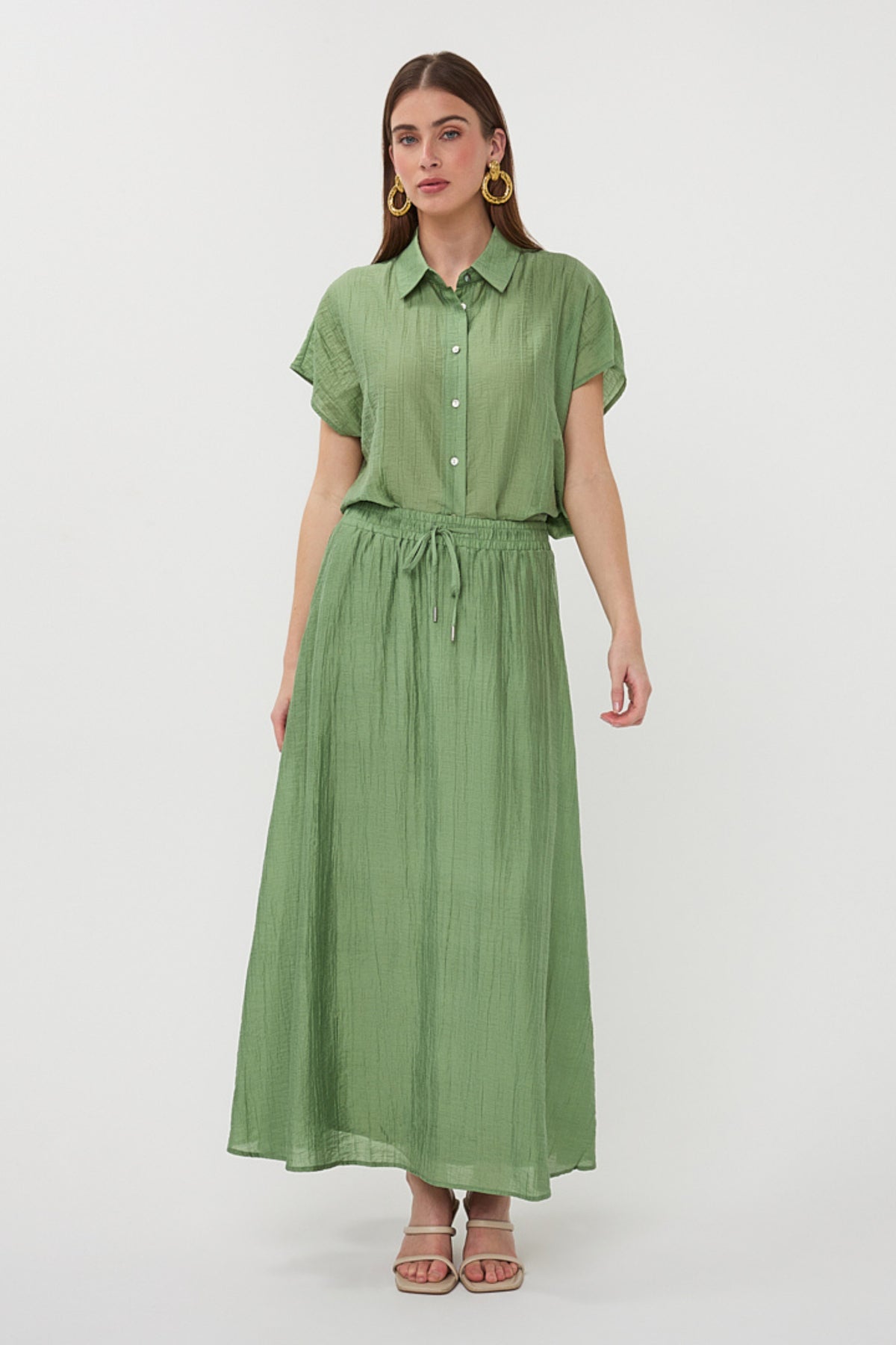 Groene batwing blouse van EsQualo met lichte crinkle-textuur en jungle groene kleur, gedragen door model.