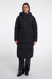 Zwarte coat van Rino & Pelle, model Zendaya, hangend aan een kapstok met een stijlvolle, moderne uitstraling.