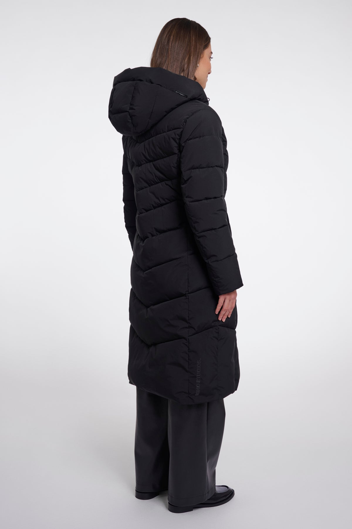 Zwarte coat van Rino & Pelle gedragen door Zendaya, zichtbaar in close-up op de afbeelding.