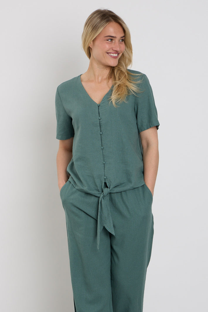 Donkere bosgroene blouse Fqlava van Freequent, met losse pasvorm en ruffle-details, zichtbaar op de afbeelding.