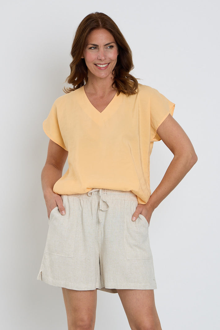 Zoso blouse Emma in apricot, lichtgewicht en losvallend, met lange mouwen en ronde hals, gedragen door een model.