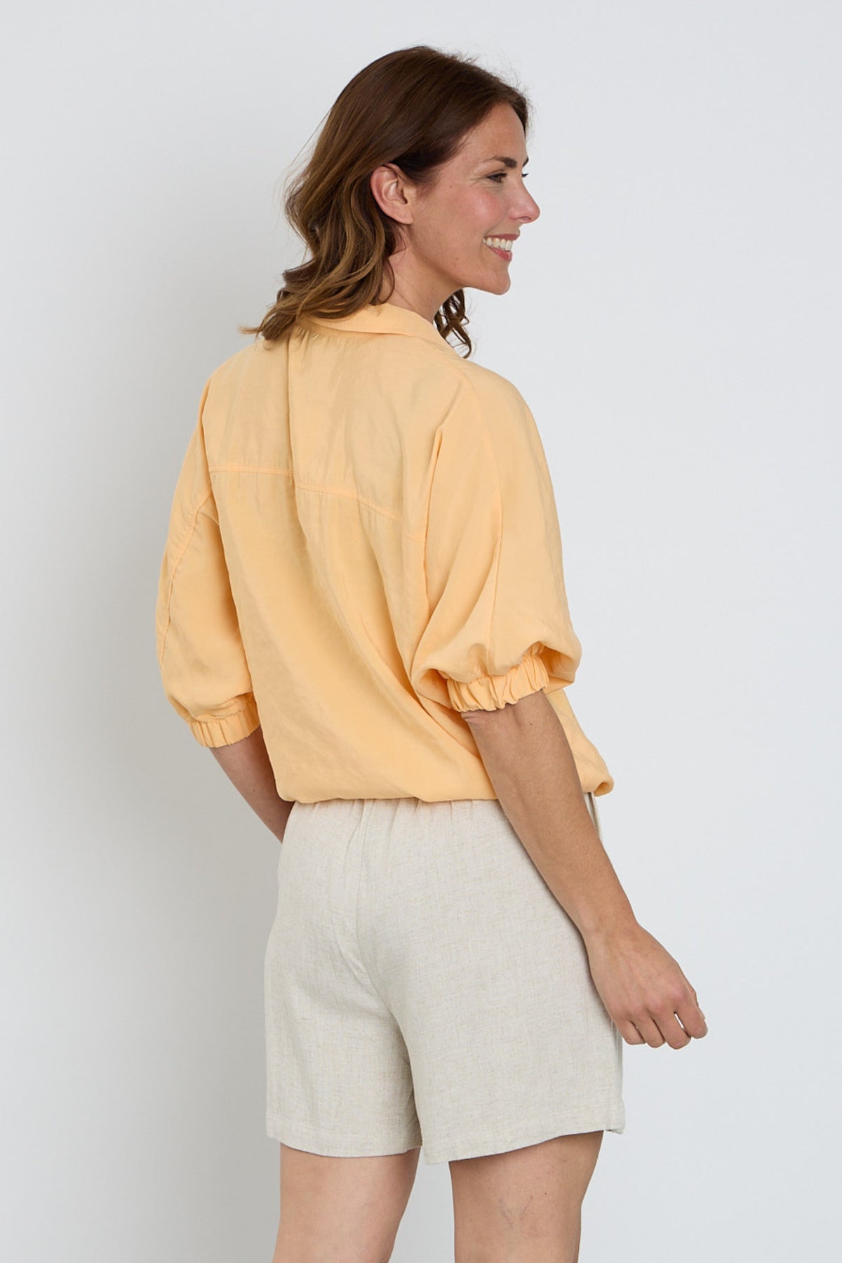 Zoso blouse Lisa Apricot 263, licht oranje top met lange mouwen en knoopsluiting, gedragen door een model.
