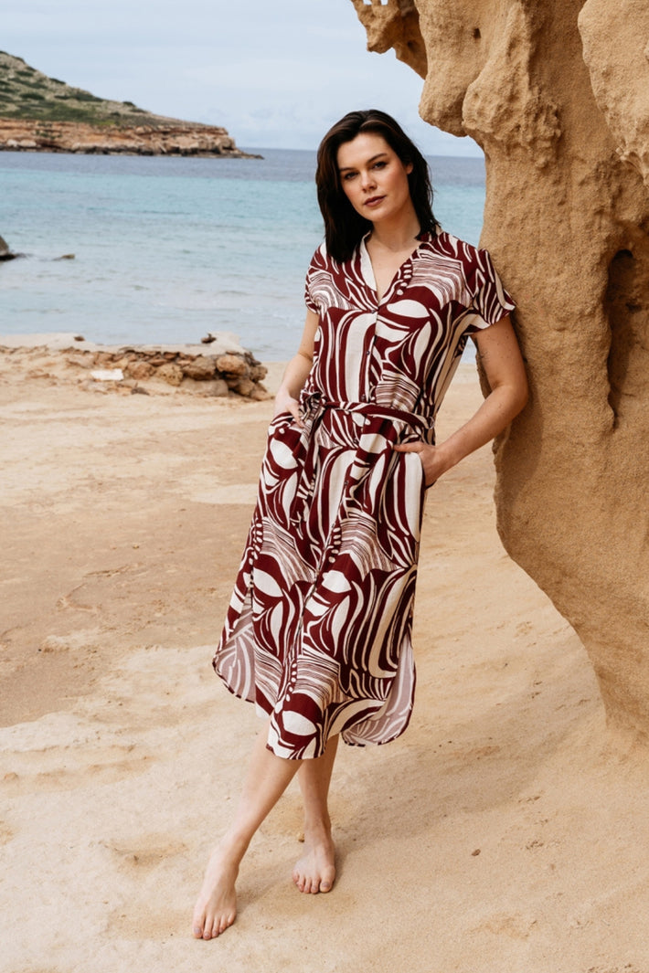Liva Weave Claret Multi jurk van &Co woman met kleurrijk geweven patroon en elegante pasvorm, gedragen door een model.