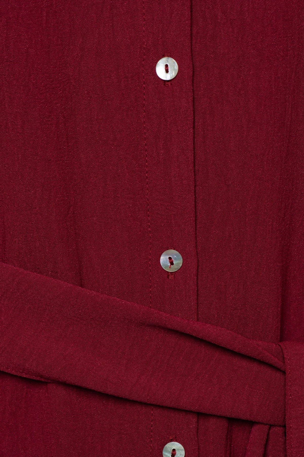 Lange, elegante Margo Claret jurk van &Co woman met subtiele details en zachte stof, gedragen door een model.
