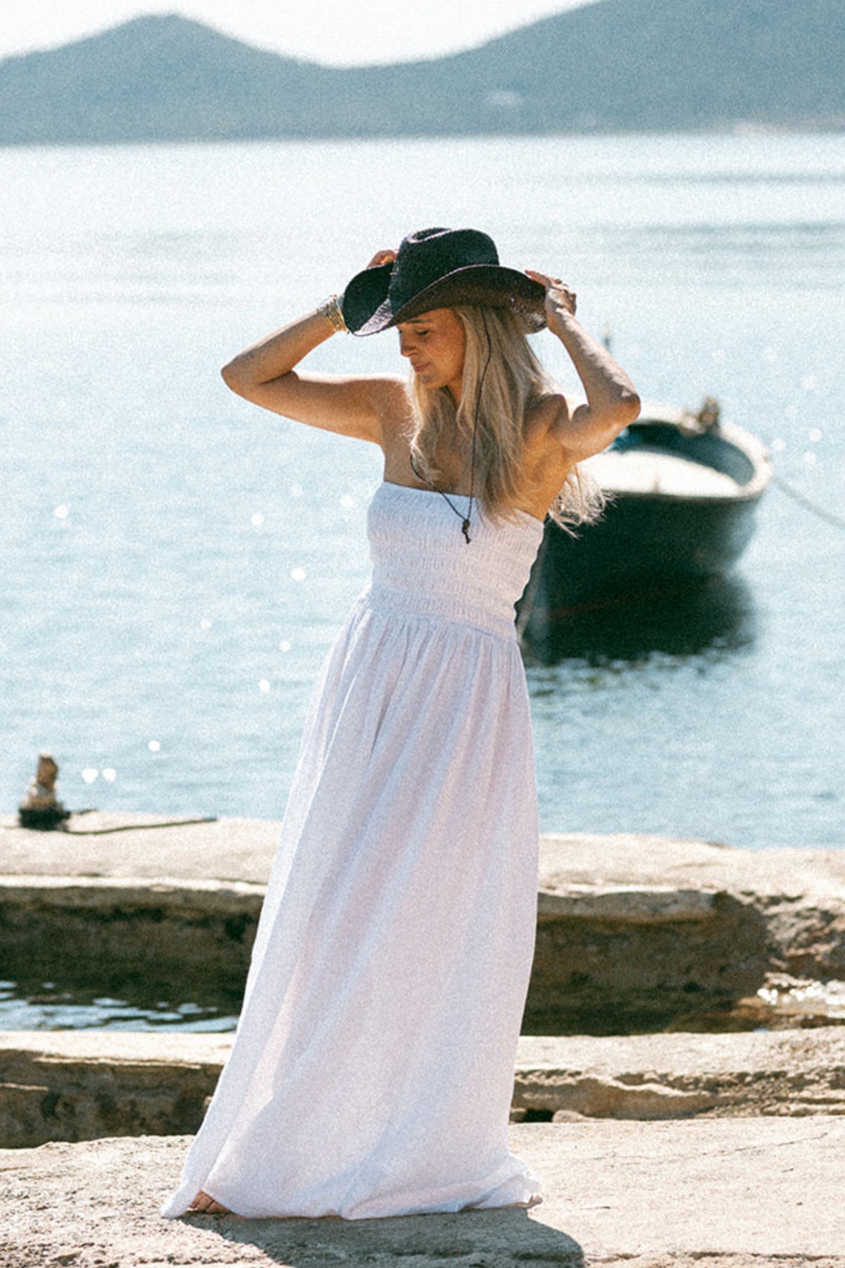 Witte strapless jurk van Bolina Island met een elegante pasvorm en lichte stof, gedragen door een model.