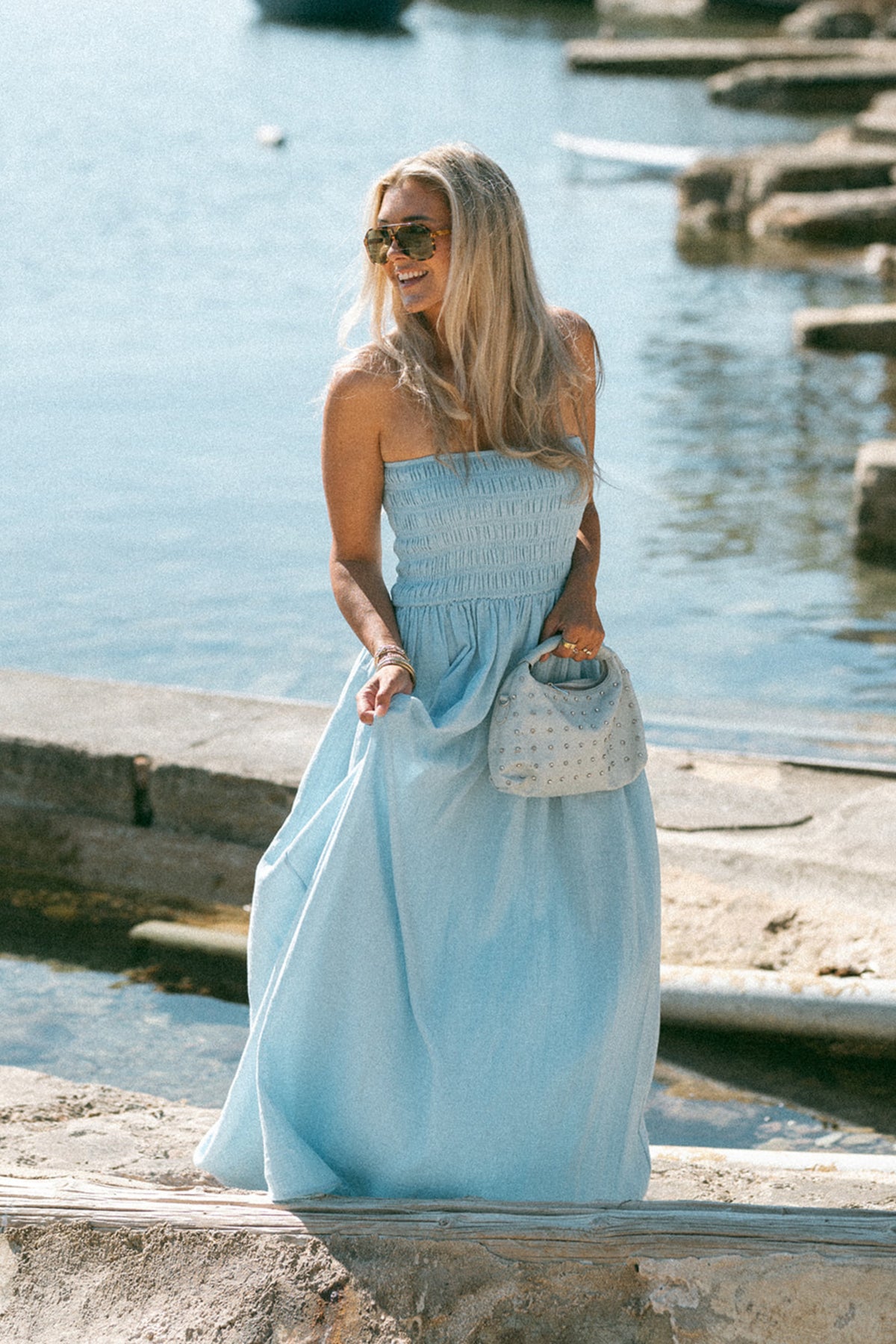 Lichte blauwe strapless jurk van Bolina Island met vloeiende stof en elegante pasvorm, ideaal voor zomerse gelegenheden.