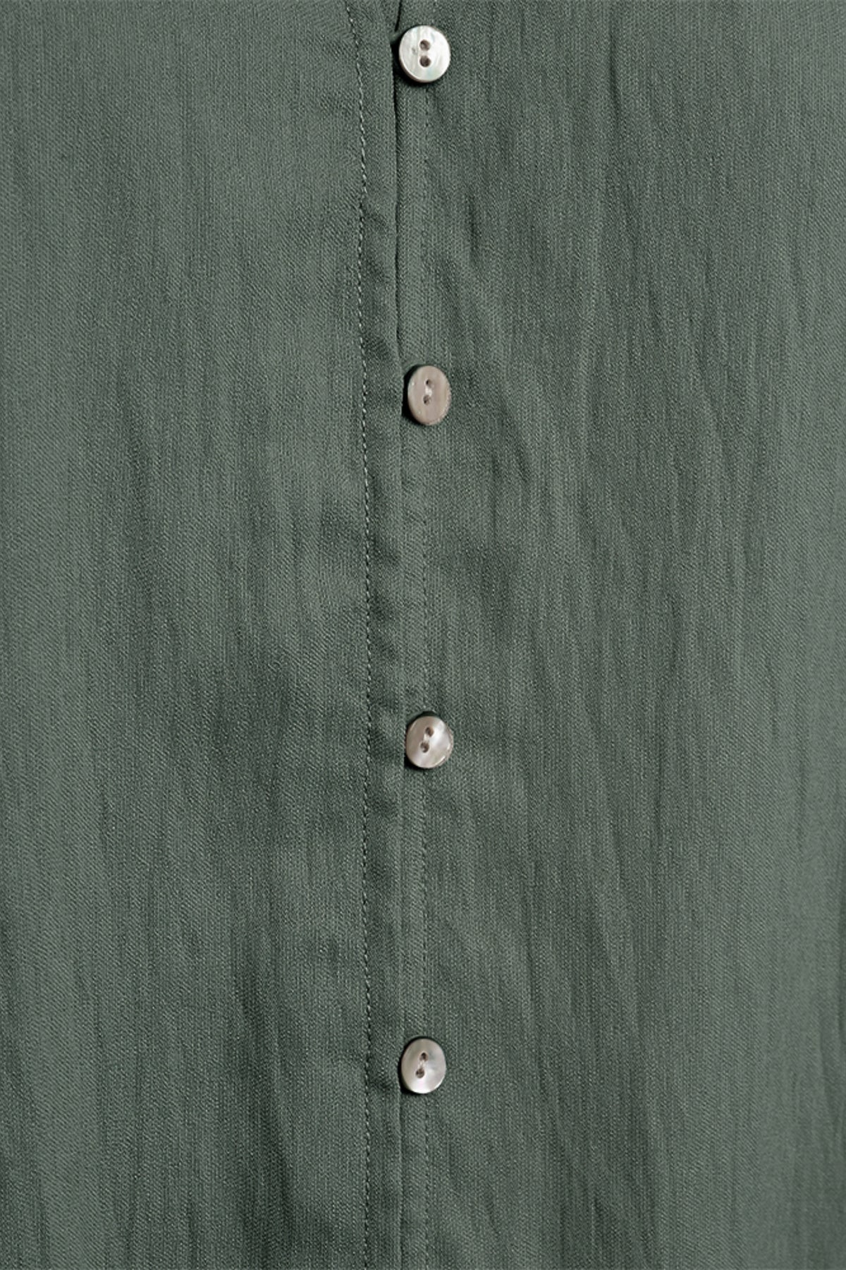 Donkere groene blouse van Freequent met lange mouwen en V-hals, gedragen door een model.