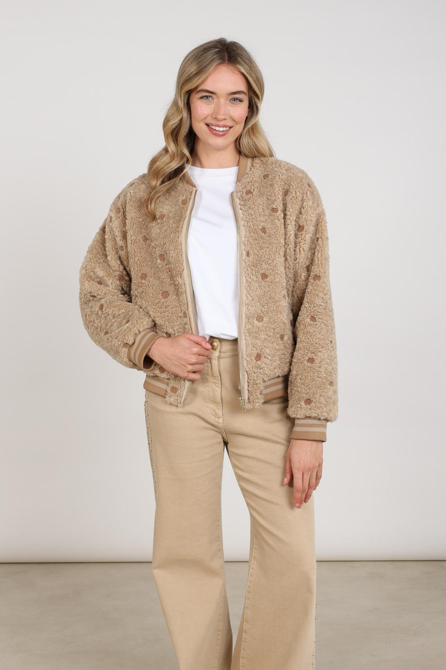 Nukus Henny Dots Sand jas met ronde stippen en rits, model voor dames, gedragen door model op een lichte achtergrond.