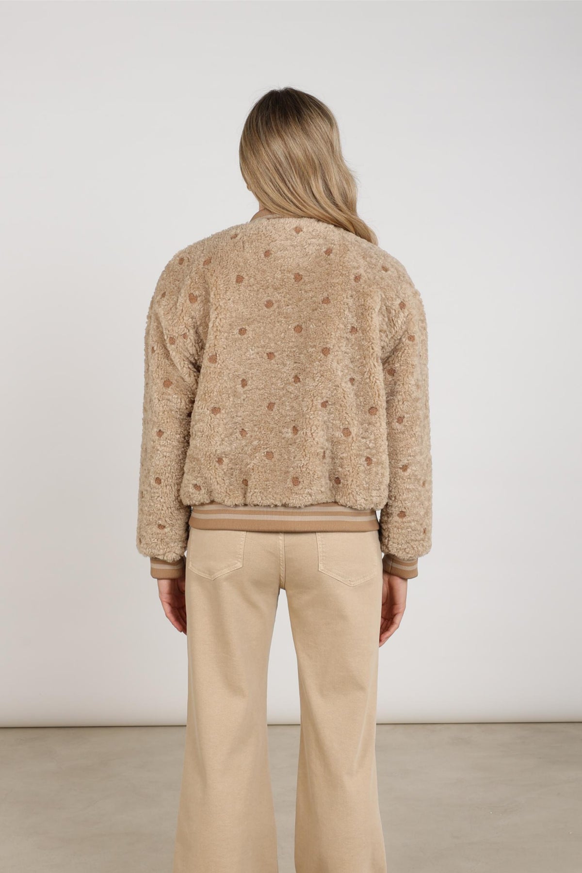 Nukus Henny Dots Sand jas met all-over print, verstelbare mouwen en zachte stof, gedragen door model.