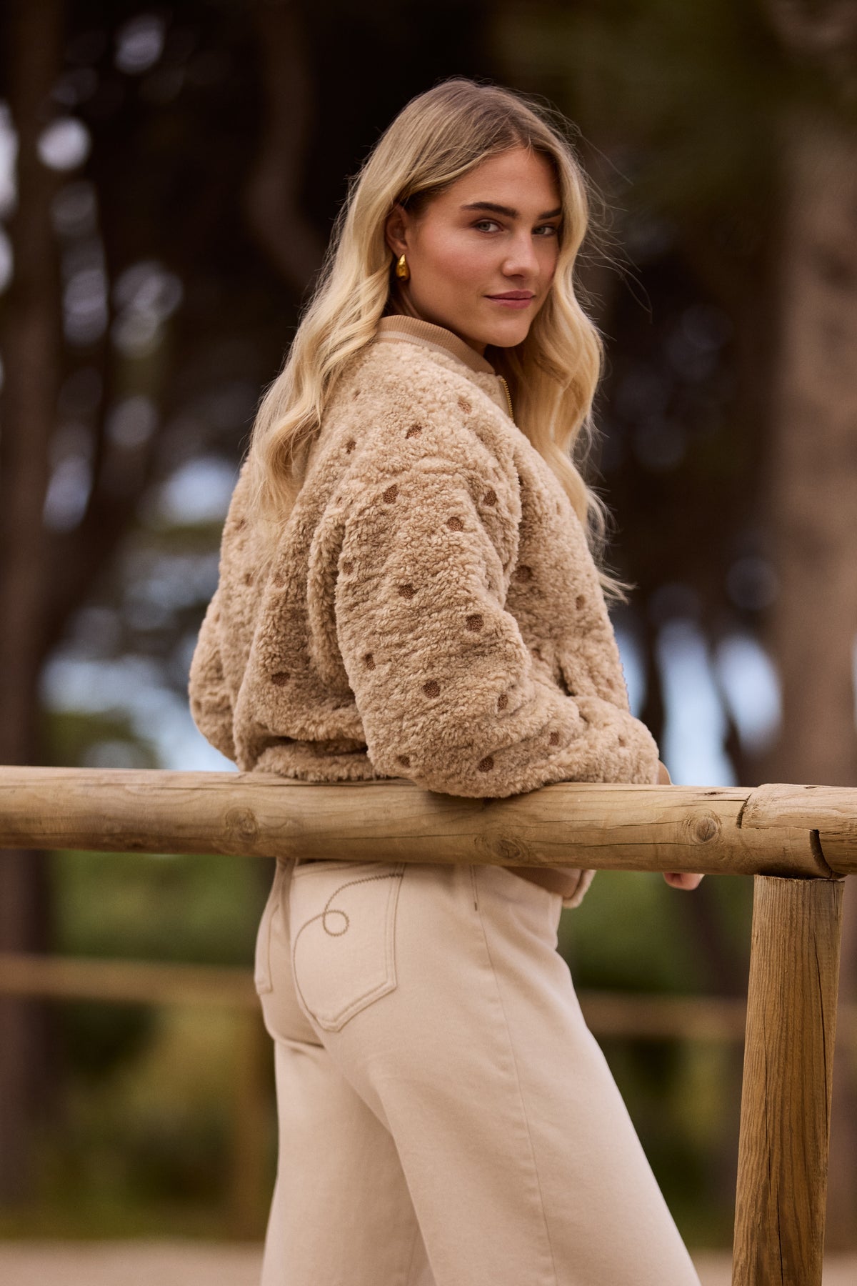 Nukus Henny Dots Sand jas met polkadot patroon en kraag, getoond op model in zandkleur, stijlvolle damesjas.