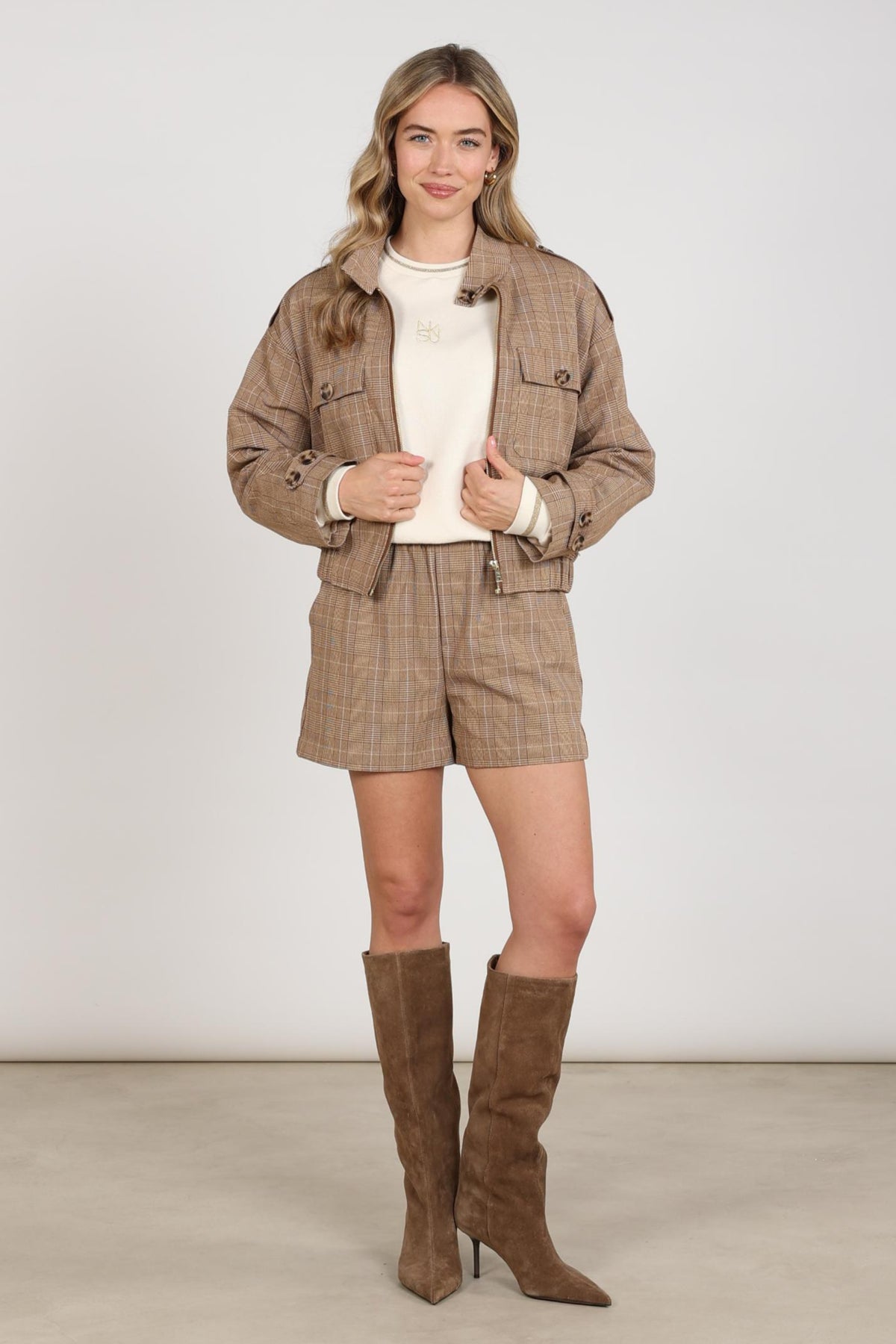 Nukus Hope Check Toffee jacket met controlepatroon en knopen, gedragen door een model, close-up van de stof en pasvorm.
