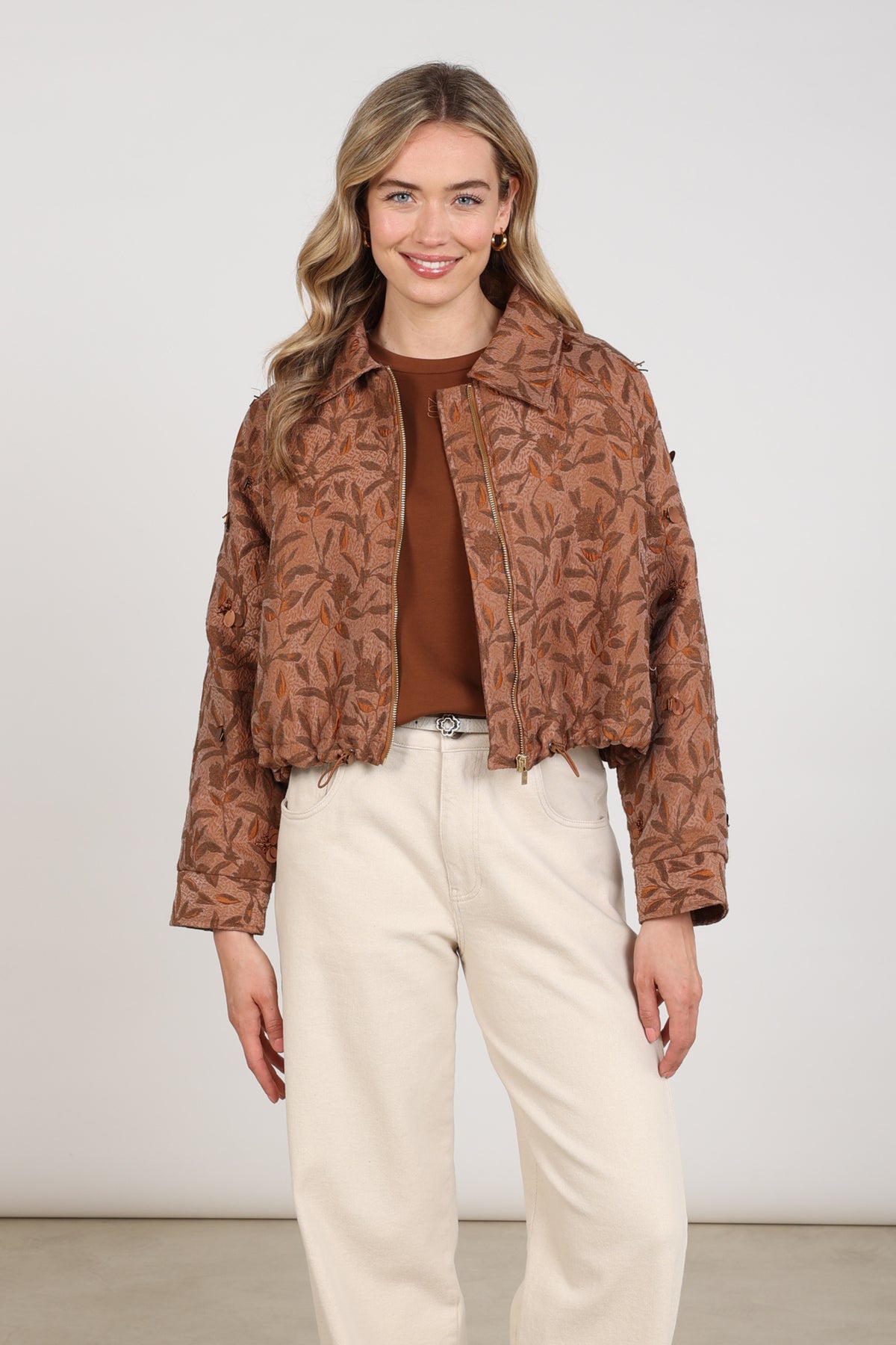Nukus Daisey Flower Toffee jas met bloemenprint en capuchon, zichtbaar op model, voor dames.