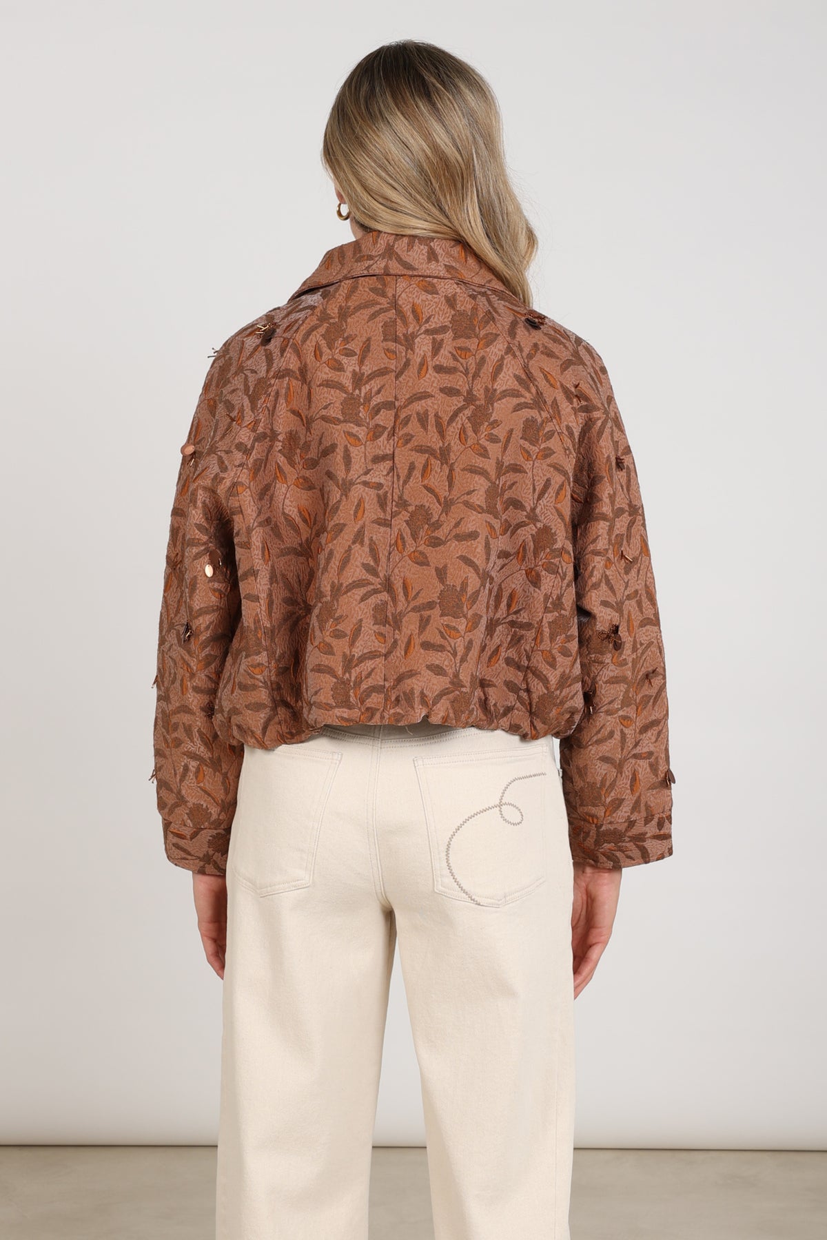 Nukus Daisey Flower toffe jas met bloemenprint, modieus en warm, gedragen door een model.
