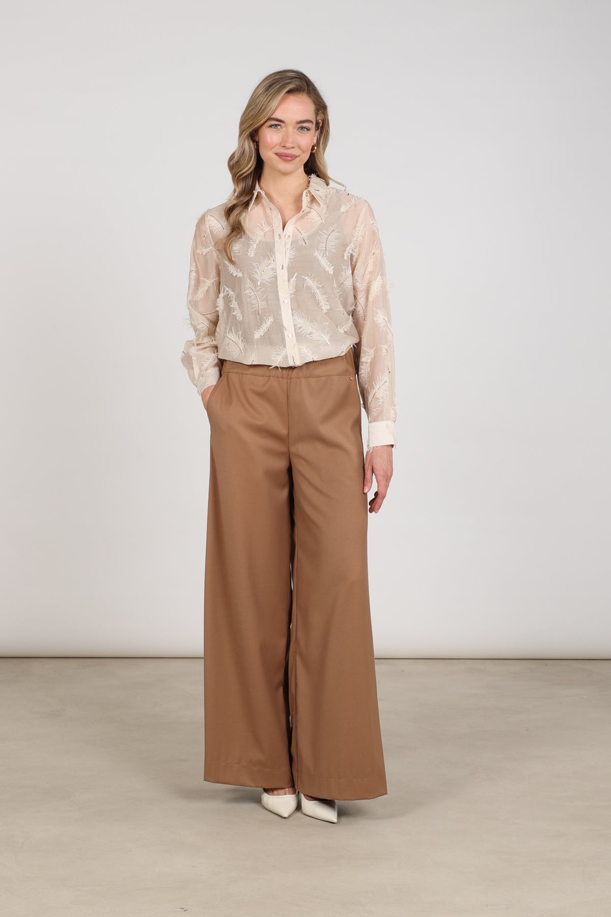 Lichte zandkleurige blouse Aysha met verenprint van Nukus, stijlvolle dameskleding voor casual en chique gelegenheden.