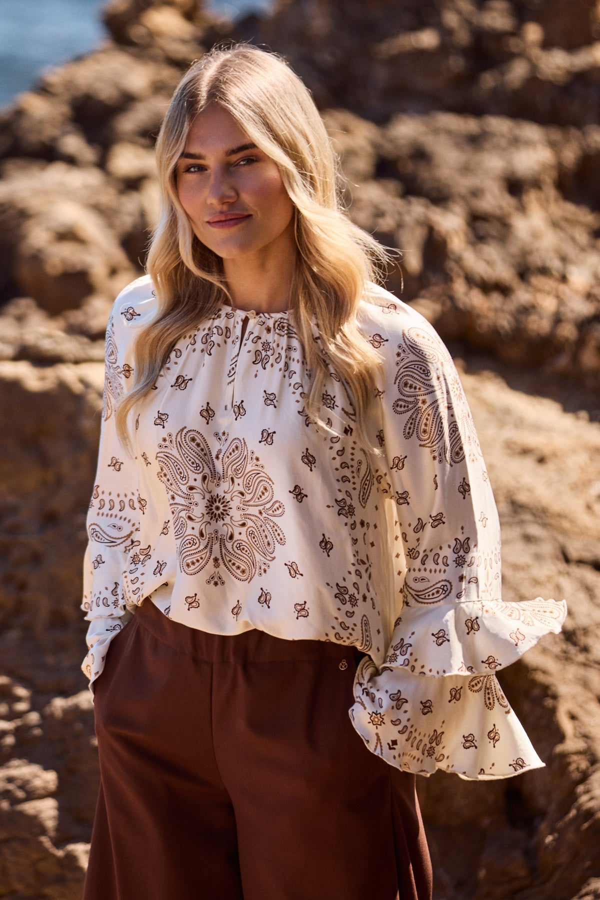 Nukus blouse Asra Paisley offwhite toffee met elegante print en losvallende pasvorm, gedragen door model.
