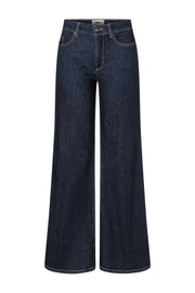 Donkere, wijde MAC Jeans met rinse-afwerking en L34 pasvorm, zichtbaar met een model die de jeans draagt.