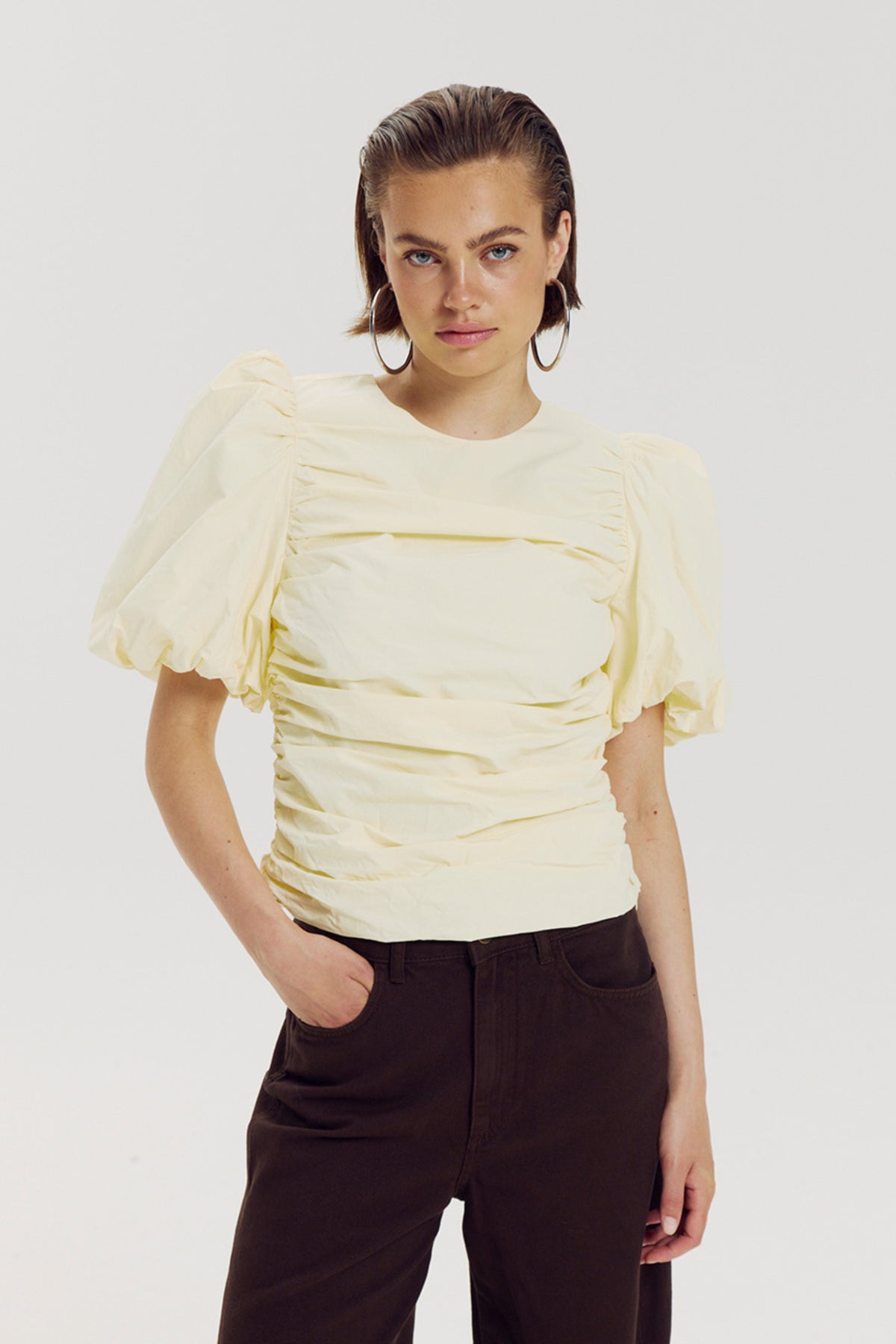 Harper & Yve Top Niko met amandelolie, modieus damestop in zachte stof, gedragen door model op lichte achtergrond.
