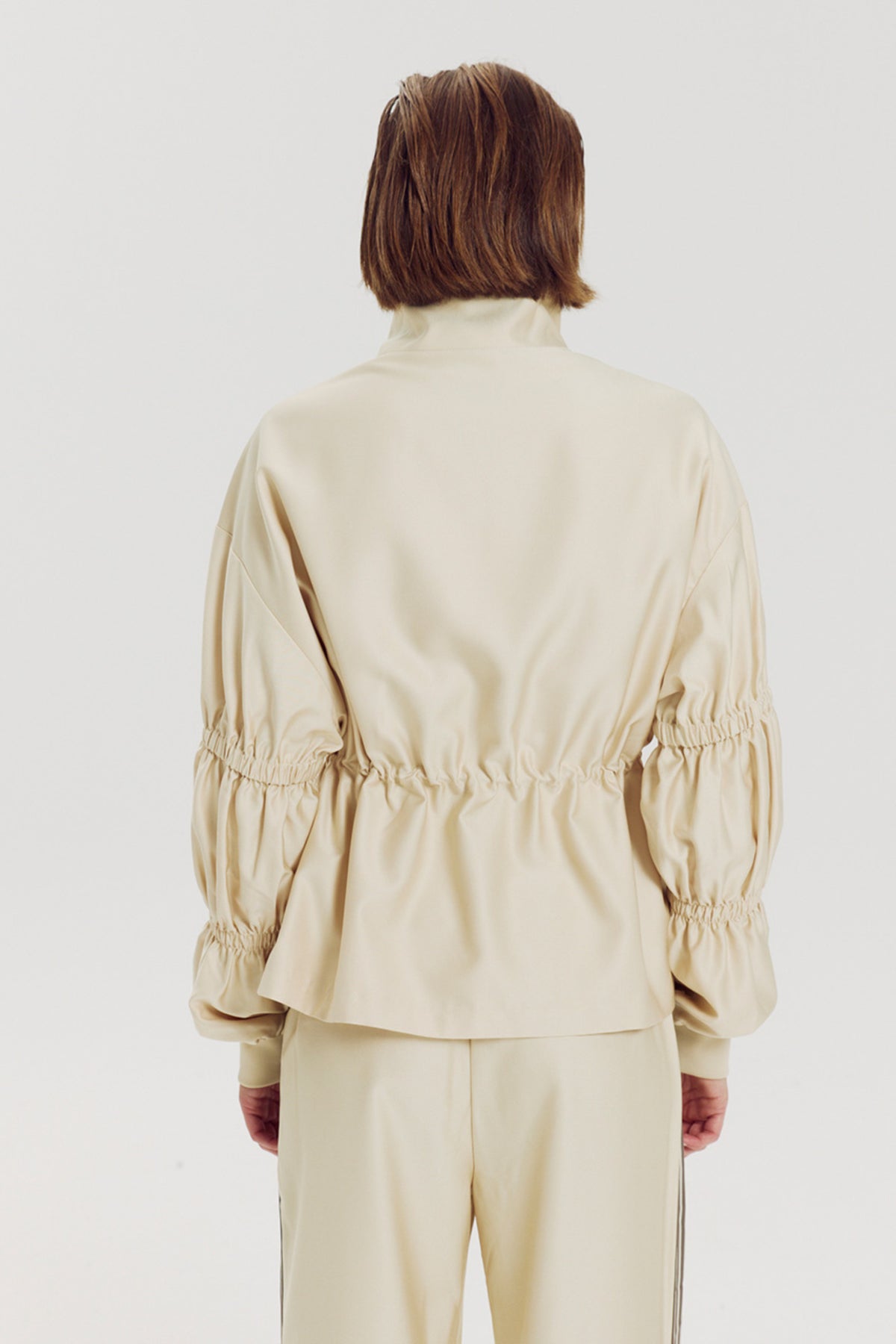Lichte Gina Almond Oil jas van Harper & Yve, model Larissa, in een stijlvolle, beige kleur met rits en zakken.