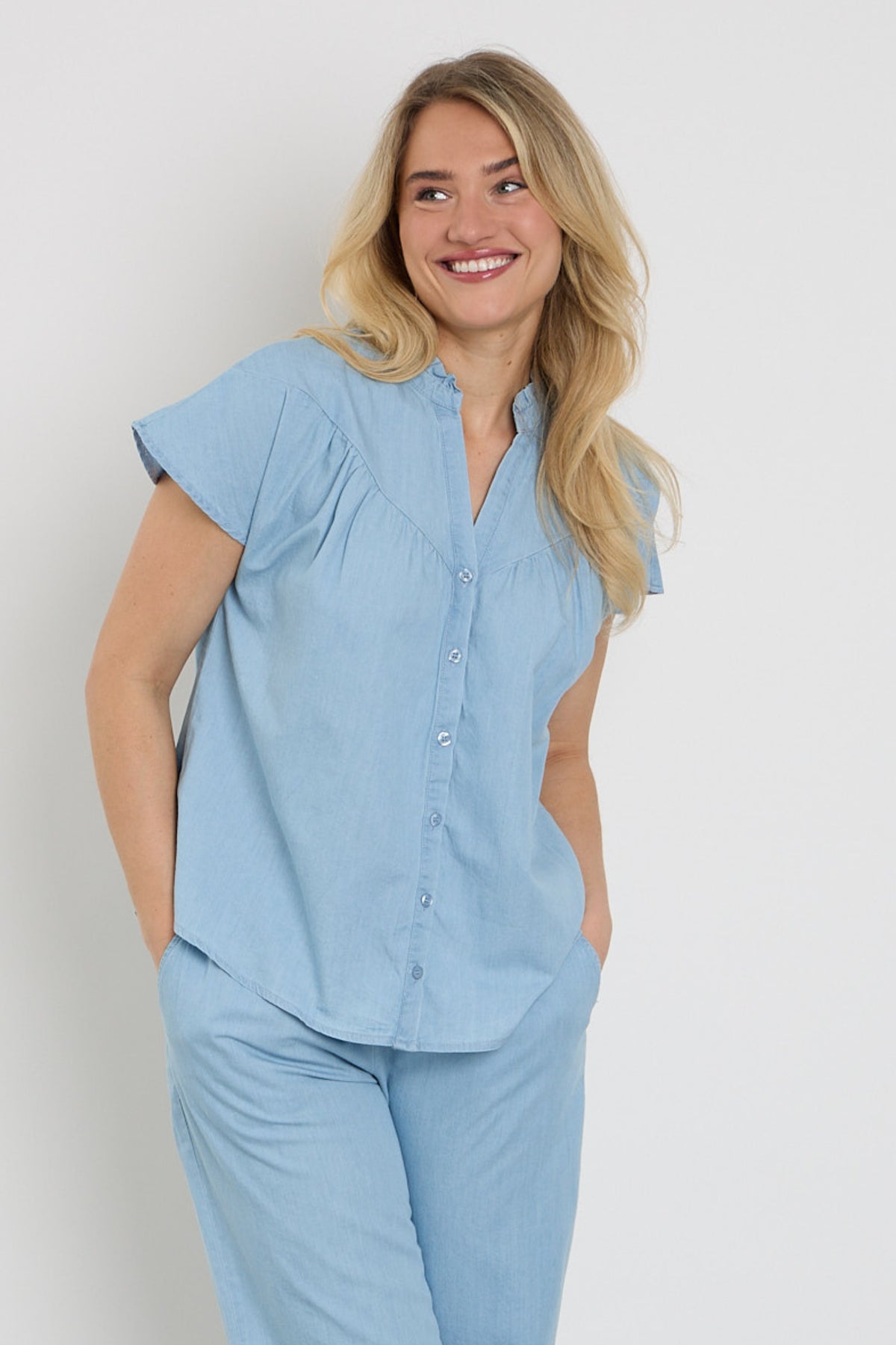 Blouse Rosan Ice Blue van Elvira Casuals met lange mouwen en ronde hals, gedragen door een model.