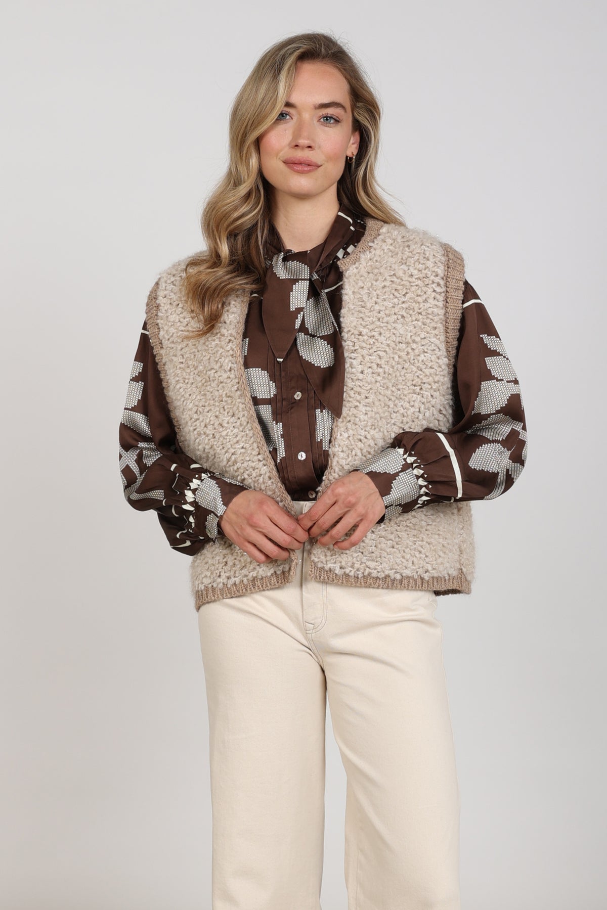 Taupe Nukus gilet Lana Sand NKF08031 met open voorkant en zachte textuur, gedragen door een persoon.