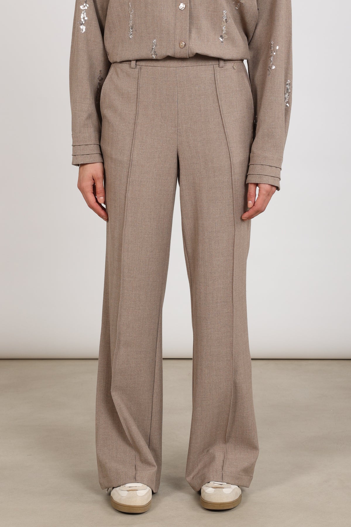 Taupe Nukus Jill broek met rechte snit en elastische taille, gedragen door een model.