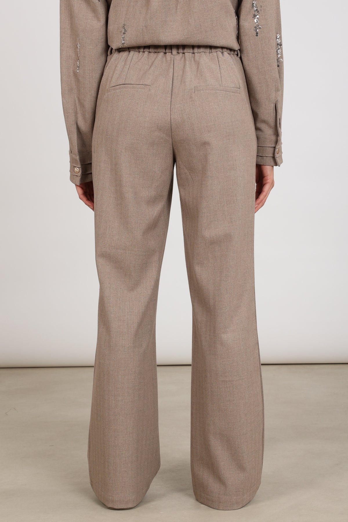 Taupe Nukus broek Jill NKF09077 met elastische taille en rechte pasvorm, gedragen door een model.