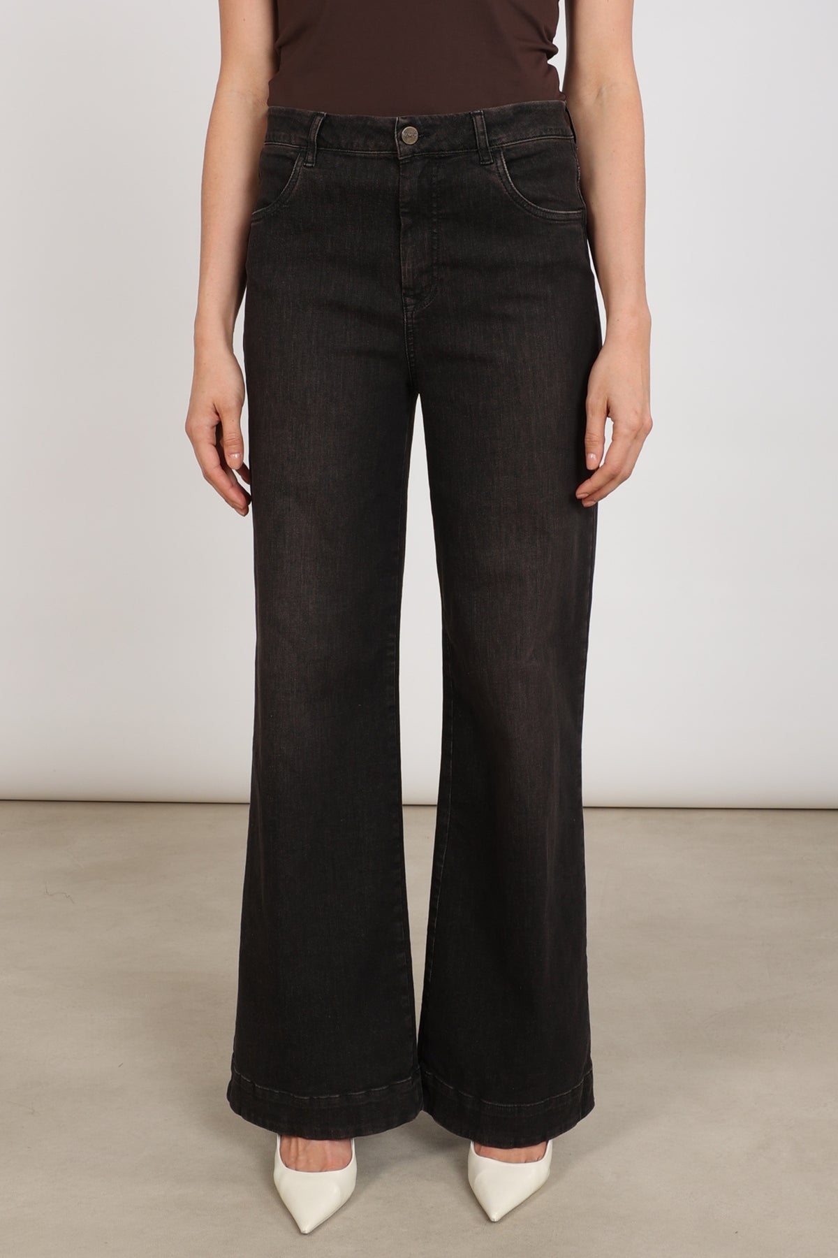 Donkere bruine jeans Abby van Nukus met rechte snit en omgeslagen zoom, gedragen door een model.
