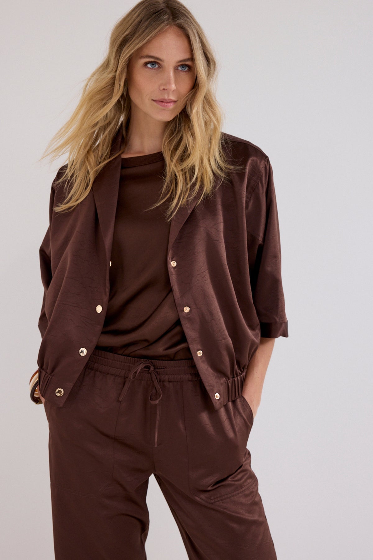 Lichte chocoladebruine blouse van Tramontana met elastische details, gedragen door een model op een witte achtergrond.