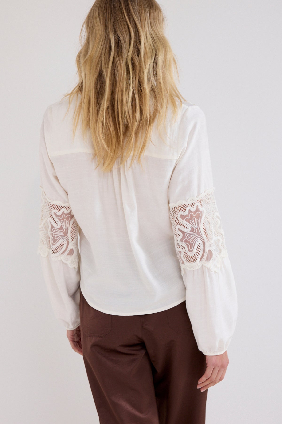 Zwart Tramontana blouse met kanten details, korte mouwen en elegante pasvorm, zichtbaar op de afbeelding.