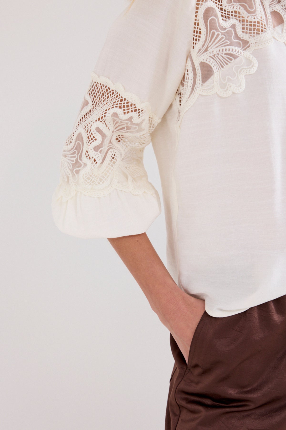 Blouse met kanten details van Tramontana, licht en elegant met fijn geborduurd lace patroon, gedragen door een model.